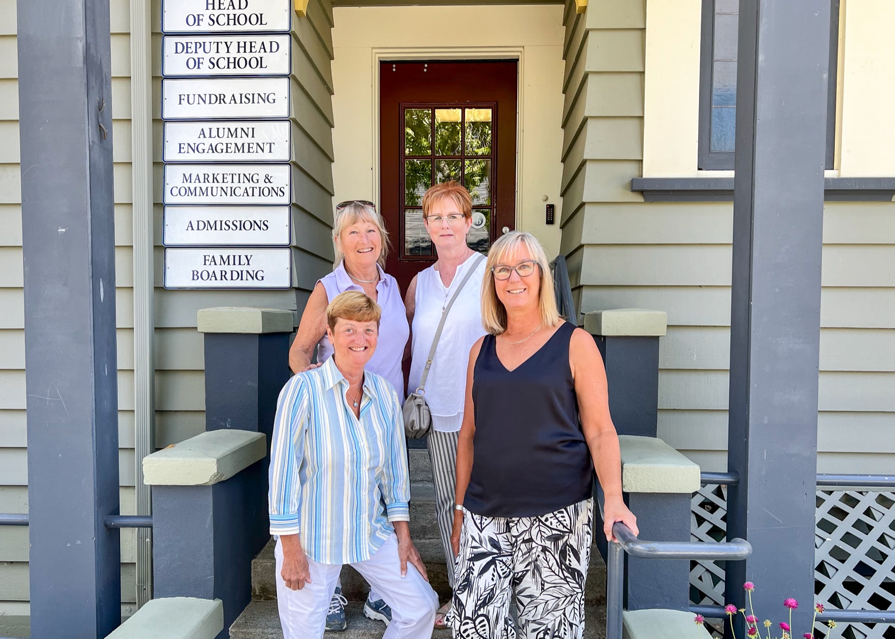 4 people standing posing for photo on stairs