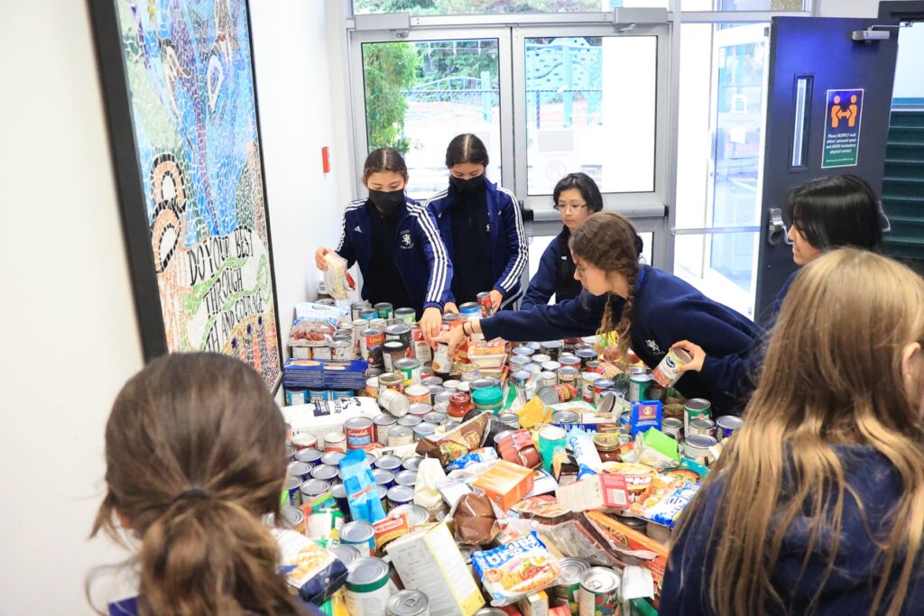 students over table of canned food