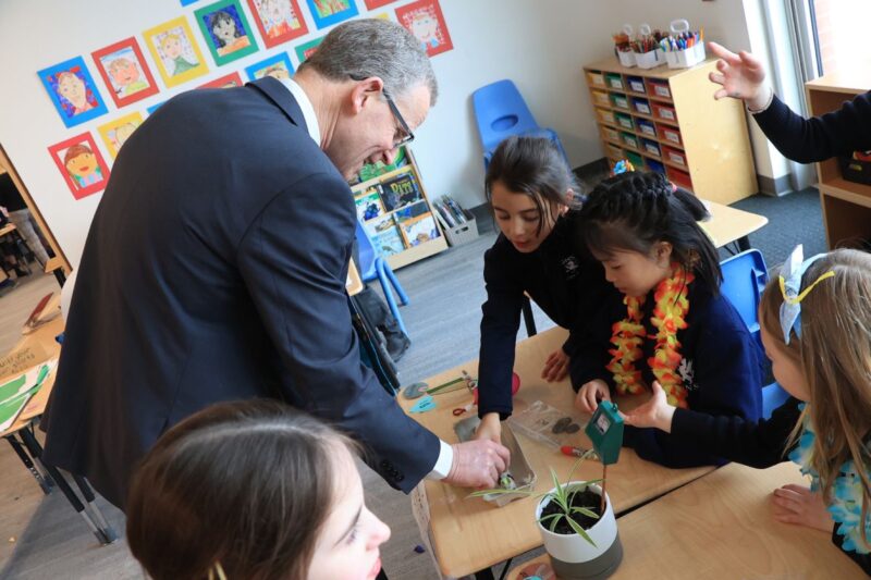 gns students with teacher playing with plant