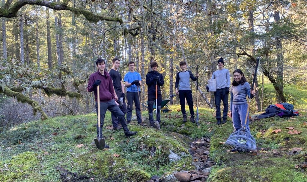 gns students with shovels in forest