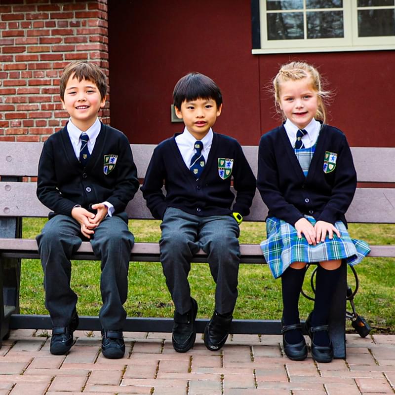Junior School students sitting on a bench