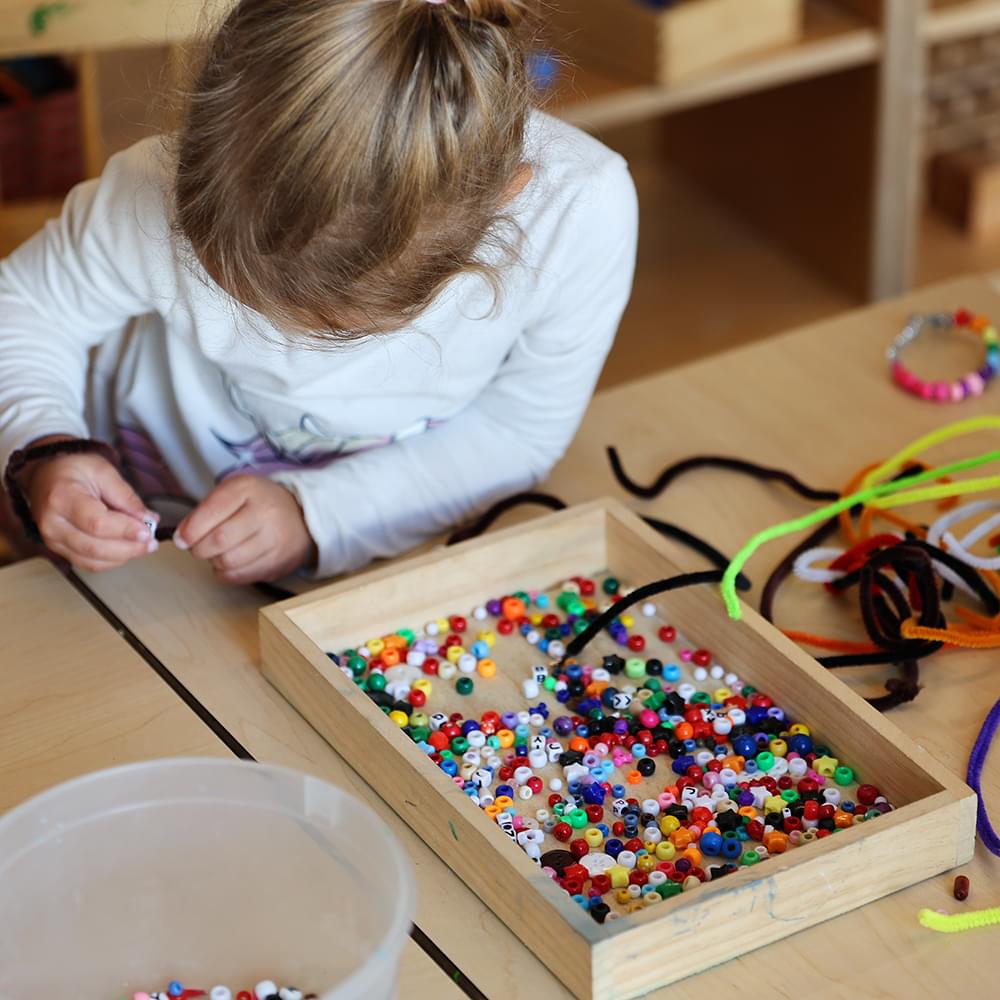 Child making something with beads