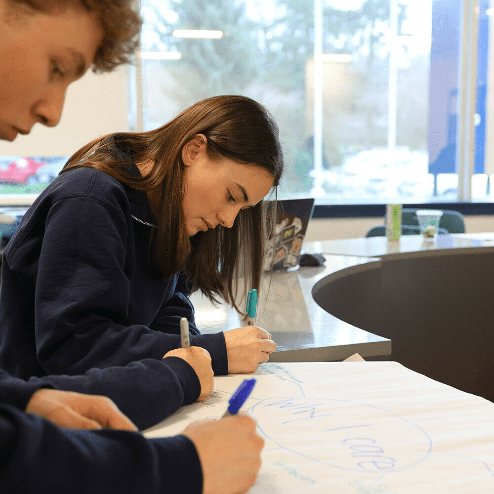 Student writing with a sharpie