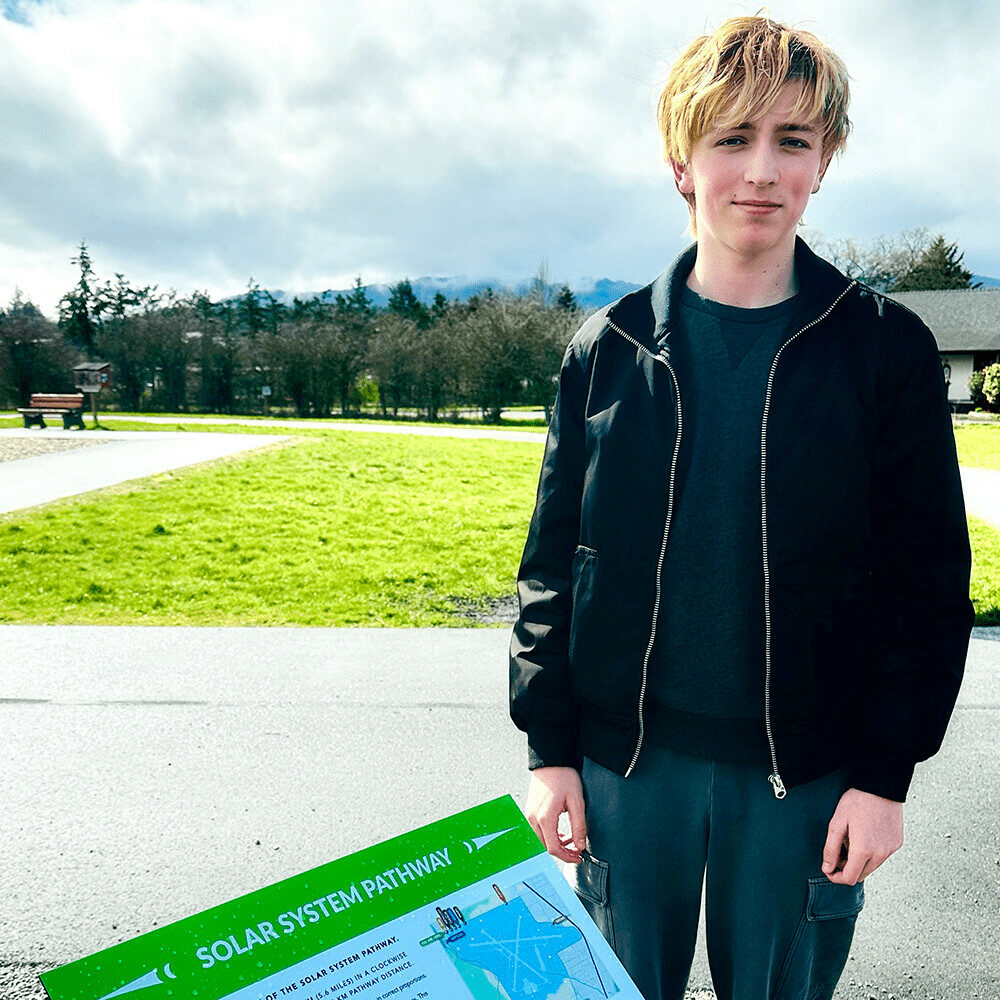 student pictured outside sign