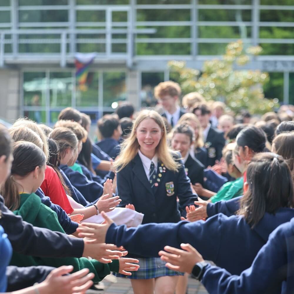 Graduating students getting high fives from Middle School