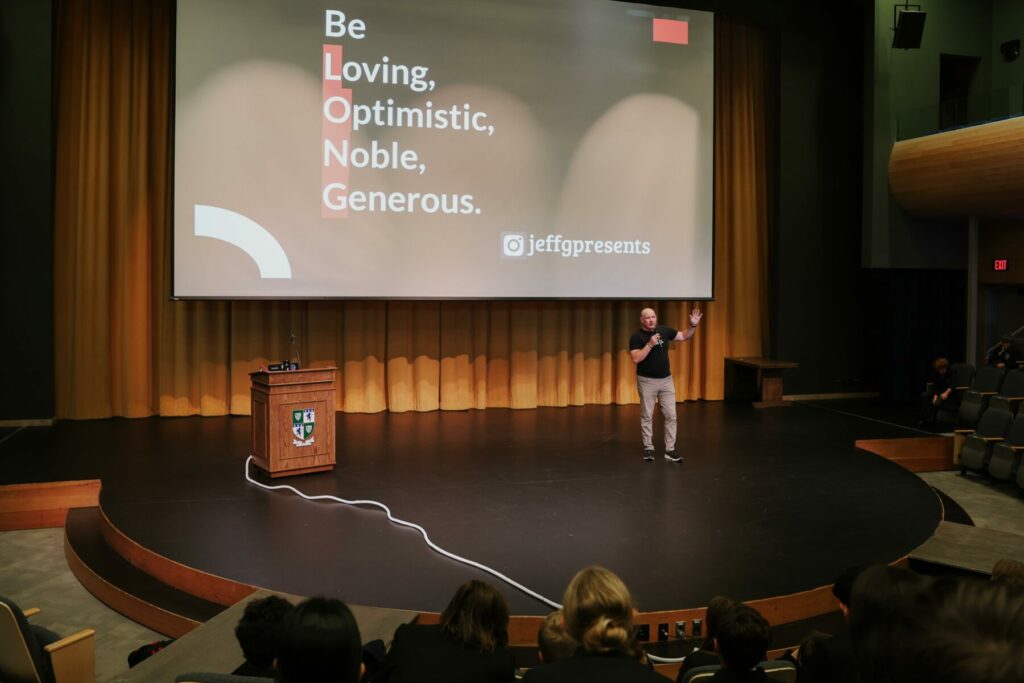 Jeff Gerber on stage at GNS with his message of Being Loving, Optimistic, Noble, and Generous.