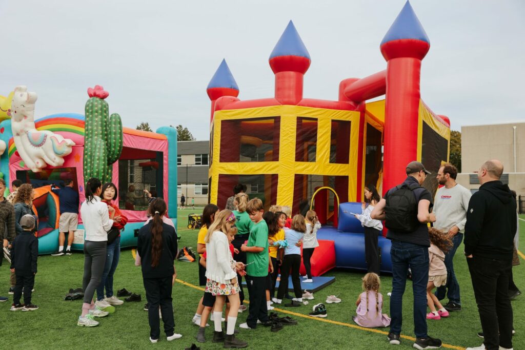 Children gather near the entrance of a large inflatable bouncy castle during the GNS Family Carnival.