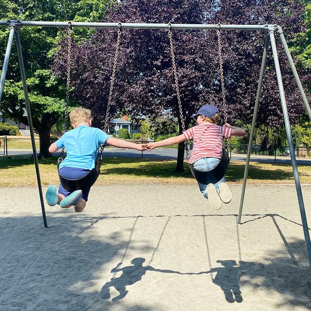 Two children on the swings at spring break camp