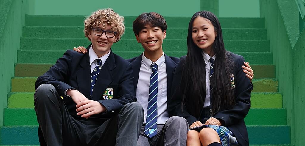 Three Senior School students sitting on our rainbow stairs