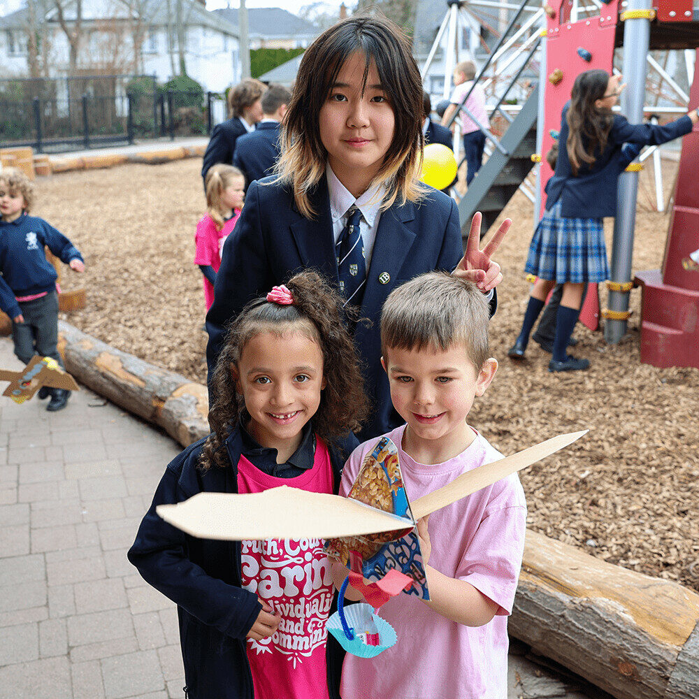 Students smiling with their paper airplane creation
