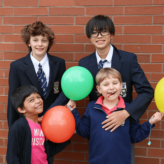 Students smiling with their balloon creation