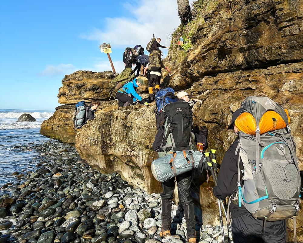 Students backpacking on coast