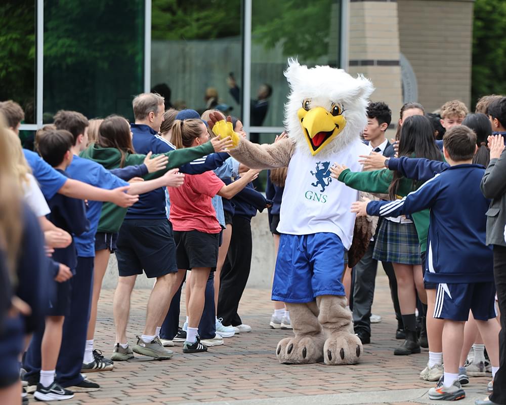 Glenlyon Norfolk School Gryphon mascot high-fiving students at an event