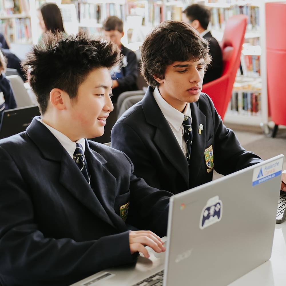 Two Glenlyon Norfolk School students working together using a laptop